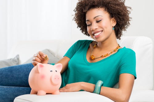 Woman Putting Coin In Piggybank